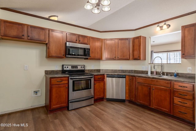 kitchen featuring sink, crown molding, a textured ceiling, dark hardwood / wood-style floors, and stainless steel appliances