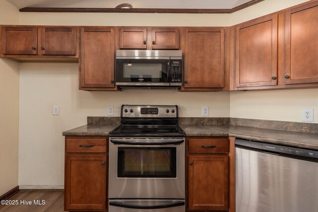 kitchen with dark hardwood / wood-style flooring and appliances with stainless steel finishes