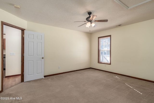 spare room with ceiling fan, light colored carpet, and a textured ceiling