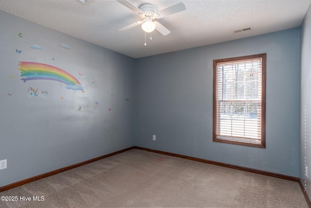 carpeted spare room with ceiling fan and a textured ceiling