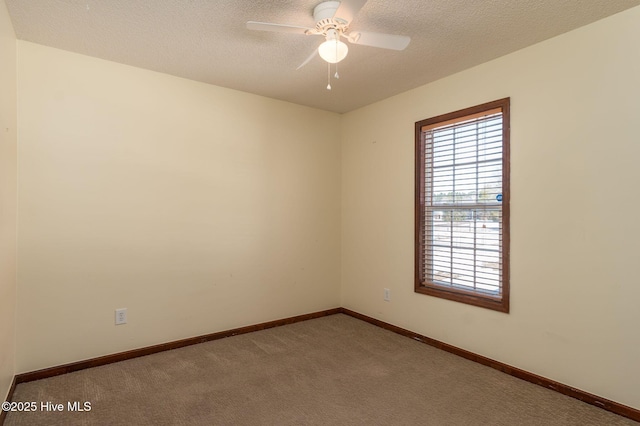 carpeted empty room with ceiling fan and a textured ceiling