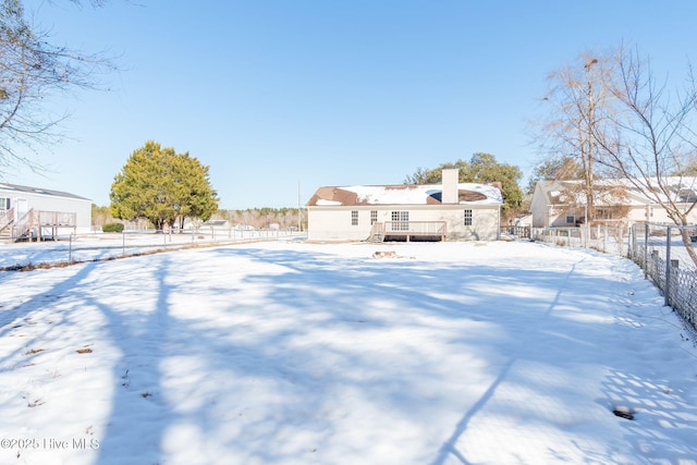 snowy yard with a wooden deck