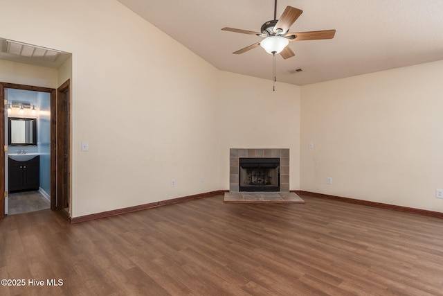 unfurnished living room with ceiling fan, a fireplace, and dark hardwood / wood-style flooring