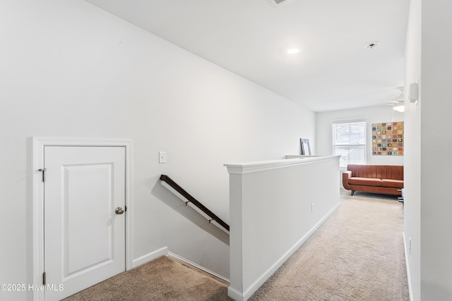 hall featuring light colored carpet