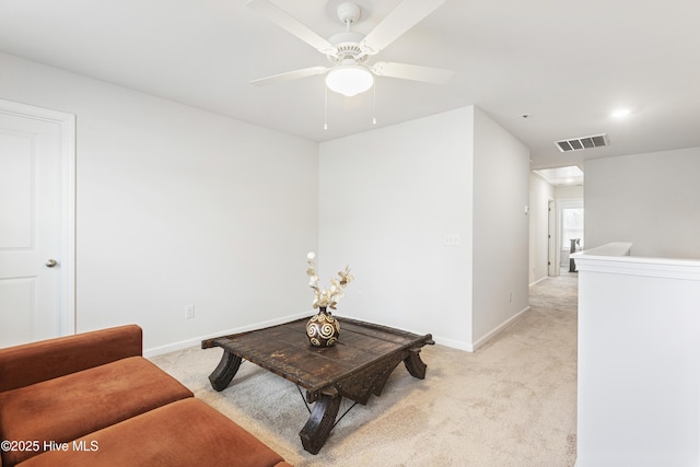 living area with light carpet and ceiling fan