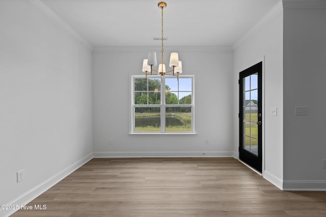 unfurnished dining area featuring crown molding, a notable chandelier, and light wood-type flooring