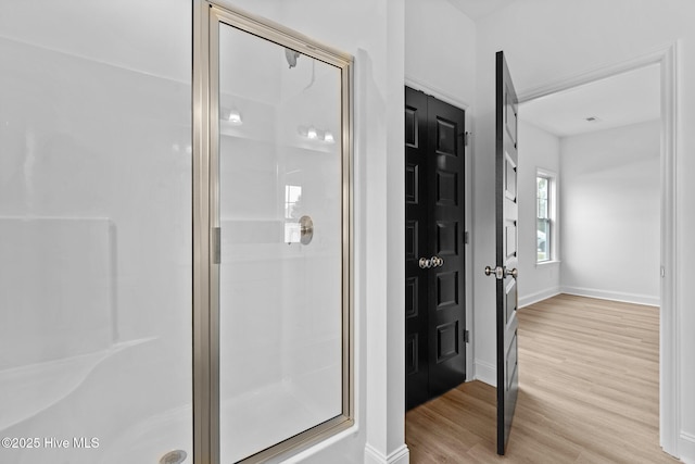 bathroom featuring hardwood / wood-style floors and an enclosed shower