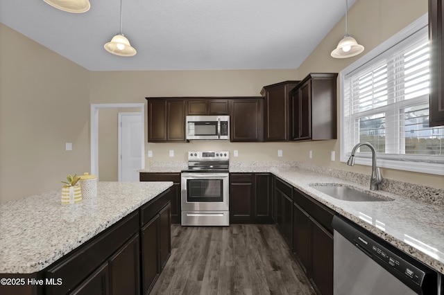 kitchen with stainless steel appliances, sink, dark hardwood / wood-style flooring, and decorative light fixtures