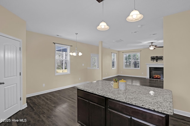 kitchen featuring dark brown cabinetry, ceiling fan, pendant lighting, and dark hardwood / wood-style flooring