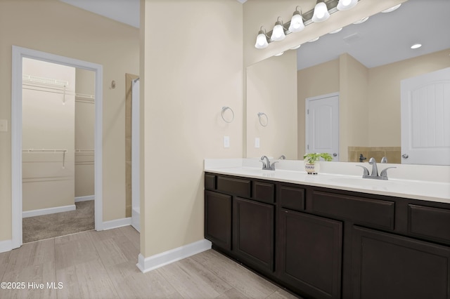 bathroom with wood-type flooring, vanity, and a shower