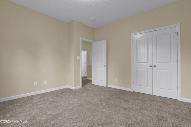 unfurnished bedroom with a closet, a textured ceiling, and carpet flooring