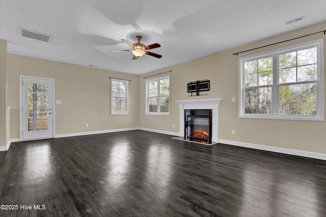 unfurnished living room featuring ceiling fan and dark hardwood / wood-style floors