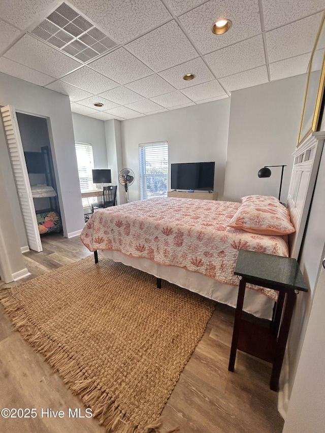 bedroom featuring hardwood / wood-style flooring and a paneled ceiling