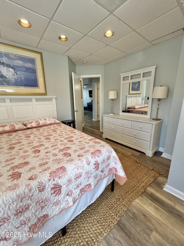 bedroom featuring a paneled ceiling and hardwood / wood-style floors