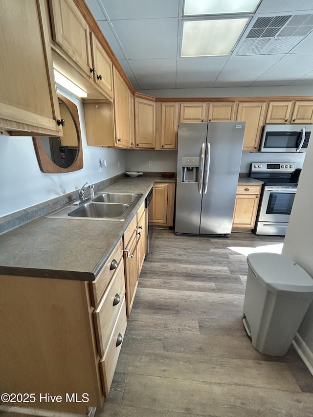 kitchen with sink, hardwood / wood-style flooring, a paneled ceiling, appliances with stainless steel finishes, and light brown cabinetry