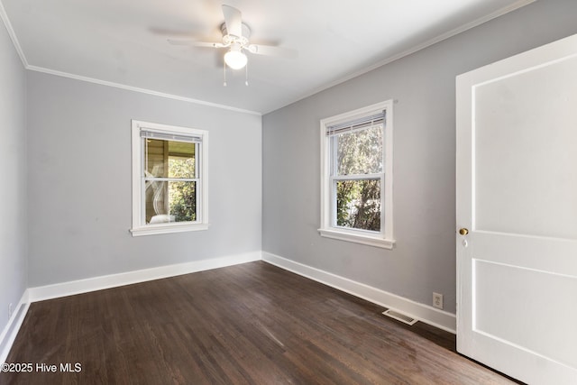 spare room with dark wood-type flooring and a wealth of natural light