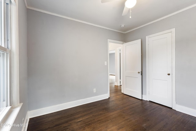 unfurnished bedroom with ornamental molding, ceiling fan, and dark hardwood / wood-style flooring