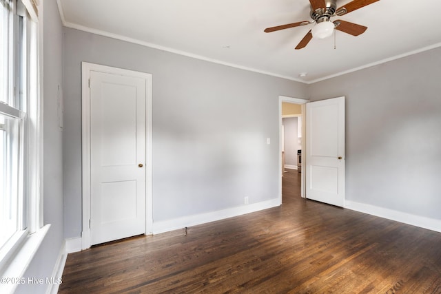 spare room with dark wood-type flooring, ceiling fan, ornamental molding, and plenty of natural light