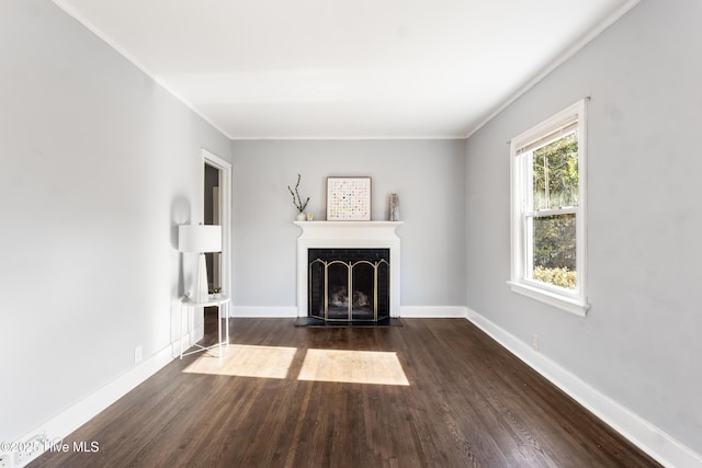 unfurnished living room with a tile fireplace, dark wood-type flooring, and ornamental molding