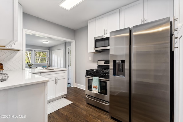 kitchen featuring white cabinetry, appliances with stainless steel finishes, light stone countertops, and sink