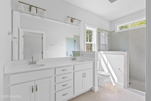 bathroom featuring tile patterned floors, vanity, toilet, and a tile shower