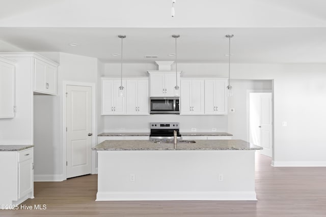 kitchen with white cabinetry, decorative light fixtures, an island with sink, and appliances with stainless steel finishes