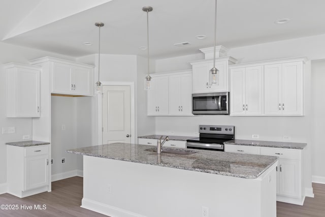 kitchen featuring pendant lighting, appliances with stainless steel finishes, a kitchen island with sink, and white cabinets