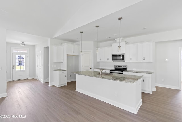 kitchen with white cabinetry, light stone counters, appliances with stainless steel finishes, an island with sink, and pendant lighting