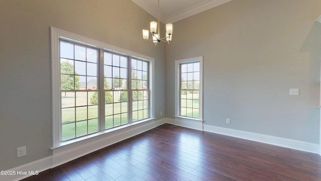 spare room featuring dark hardwood / wood-style flooring, vaulted ceiling, a notable chandelier, and ornamental molding