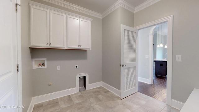 clothes washing area featuring electric dryer hookup, gas dryer hookup, cabinets, ornamental molding, and washer hookup