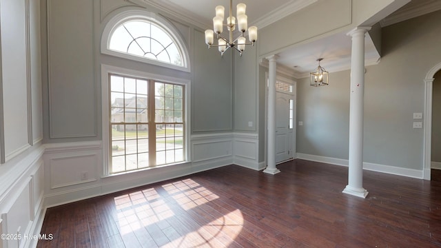 unfurnished dining area with ornamental molding, decorative columns, a notable chandelier, and dark hardwood / wood-style flooring