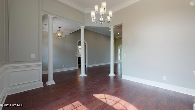 unfurnished dining area with dark hardwood / wood-style flooring, a chandelier, ornate columns, and ornamental molding