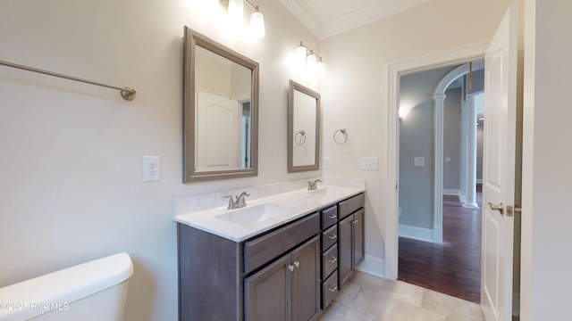 bathroom with vanity, toilet, and ornamental molding