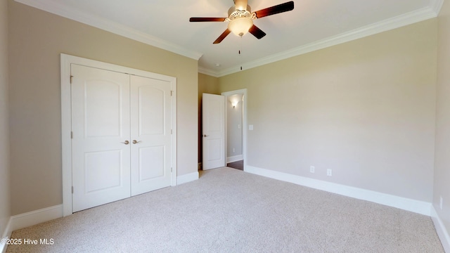 unfurnished bedroom with ceiling fan, a closet, crown molding, and carpet floors