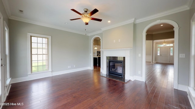 unfurnished living room with a high end fireplace, dark hardwood / wood-style flooring, ornate columns, ceiling fan, and crown molding