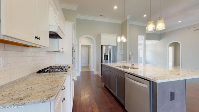 kitchen featuring white cabinets, hanging light fixtures, a kitchen island with sink, and appliances with stainless steel finishes