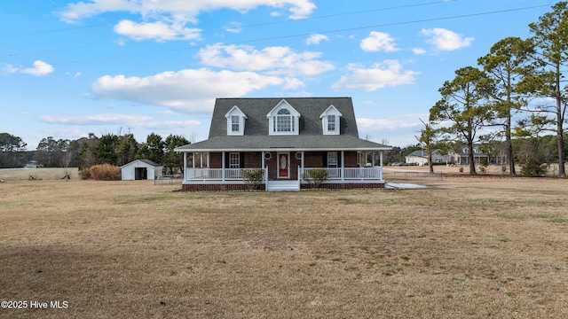 farmhouse inspired home featuring a porch, a storage shed, and a front lawn