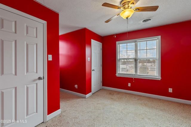 unfurnished room with a textured ceiling, light colored carpet, and ceiling fan