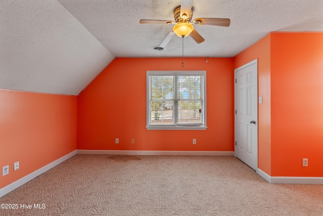 bonus room with vaulted ceiling, light colored carpet, ceiling fan, and a textured ceiling