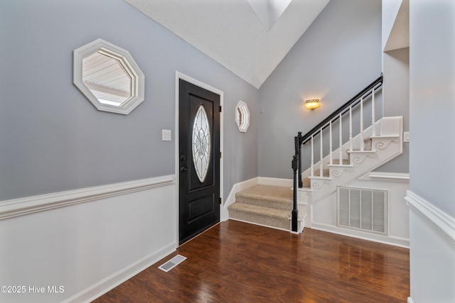 foyer with lofted ceiling and dark hardwood / wood-style flooring