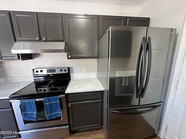 kitchen with light stone counters, appliances with stainless steel finishes, and dark hardwood / wood-style flooring