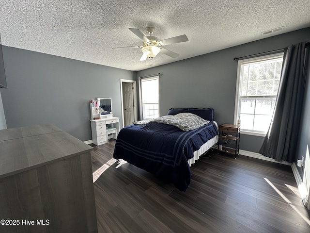 bedroom featuring ceiling fan, a textured ceiling, and dark hardwood / wood-style flooring