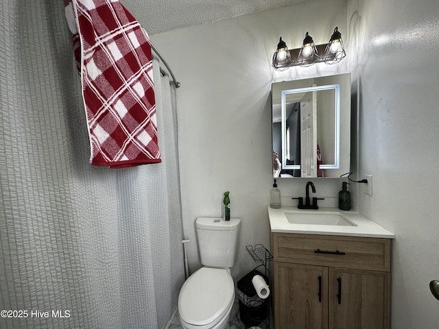 bathroom featuring vanity, a textured ceiling, toilet, and walk in shower