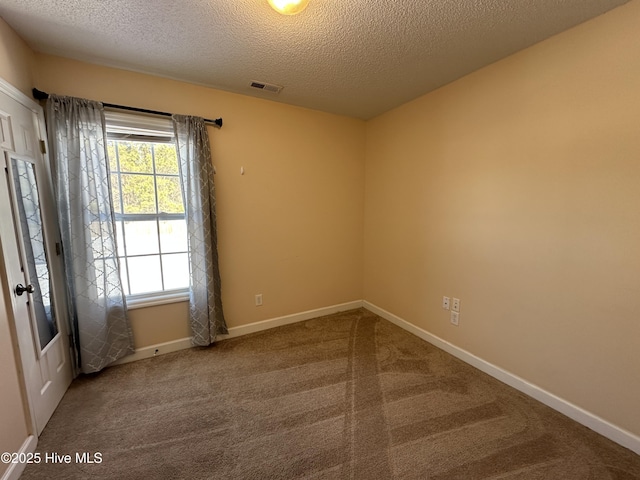 empty room featuring carpet floors and a textured ceiling