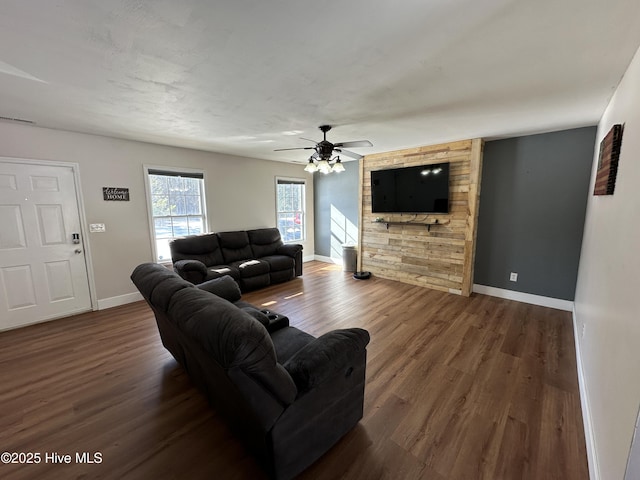 living room featuring dark wood-type flooring and ceiling fan