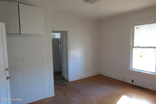 unfurnished bedroom with ornamental molding, a closet, and light wood finished floors