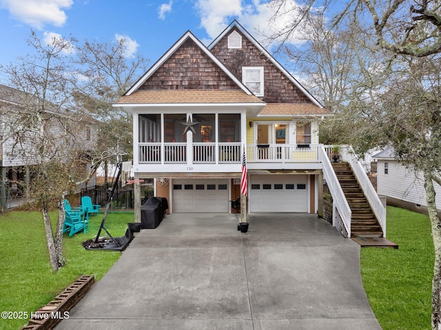 view of front of house with a porch, a garage, a front lawn, and a sunroom