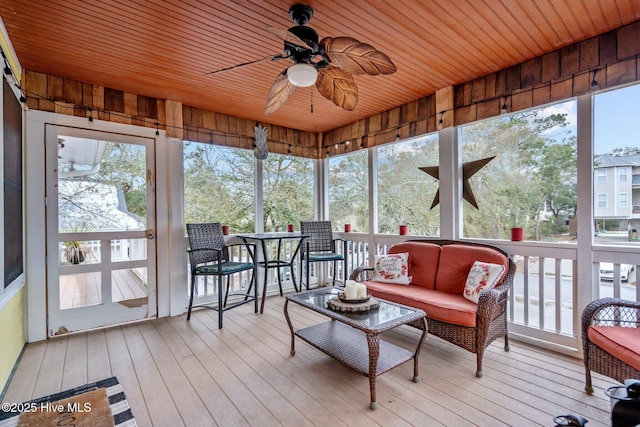 sunroom / solarium with a wealth of natural light, wooden ceiling, and ceiling fan