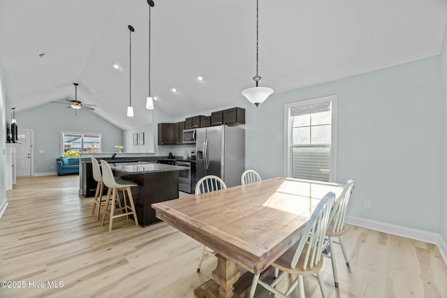 dining space featuring vaulted ceiling, ceiling fan, and light hardwood / wood-style floors