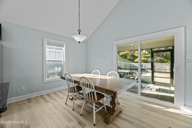 dining area with high vaulted ceiling, a healthy amount of sunlight, and light hardwood / wood-style floors